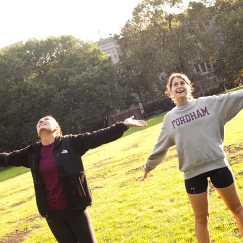 Two female students stretching in rain - LG