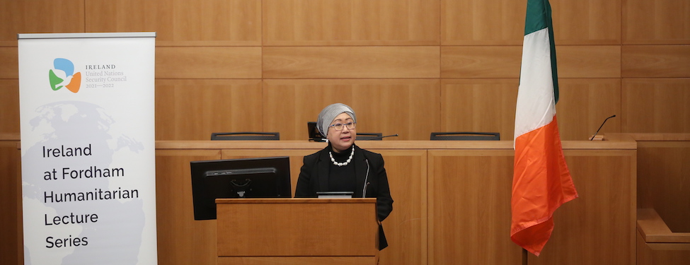 Speaker, Dr. Jemilah Mahmood, stands at the podium in the law school moot courtroom delivering her speech for the Ireland at Fordham Humanitarian Lecture Series