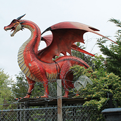 Image: a giant yard ornament of a fierce looking red dragon at shop in New York's Long Island