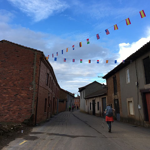 Student walking in the Spanish town of Camino, beneath banners