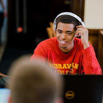 Student Wearing Headphones in Library