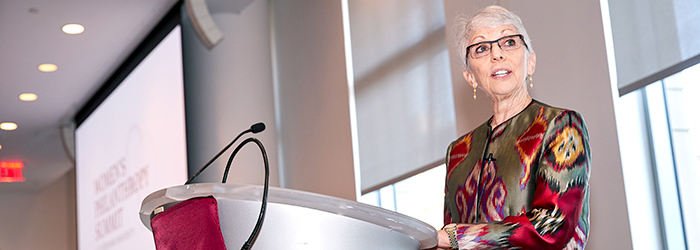 Woman speaking at podium at the women's philanthropy summit