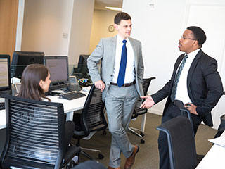 Faculty and students talking in classroom