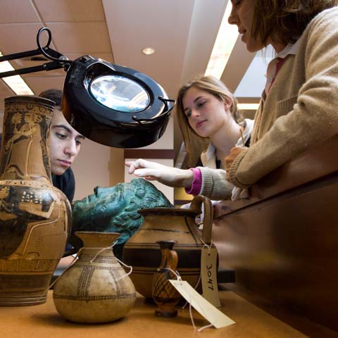 Three students examining art object - LG