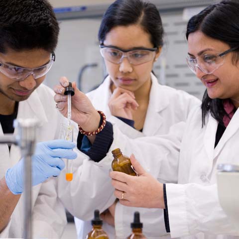 Three female students with test tubes - LG