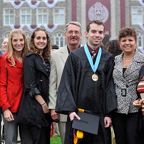 Male grad posing with family - LG