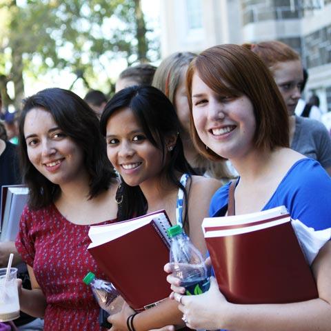 Three Female Students Carrying Books