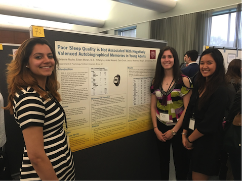 Three women in front of scientific poster 